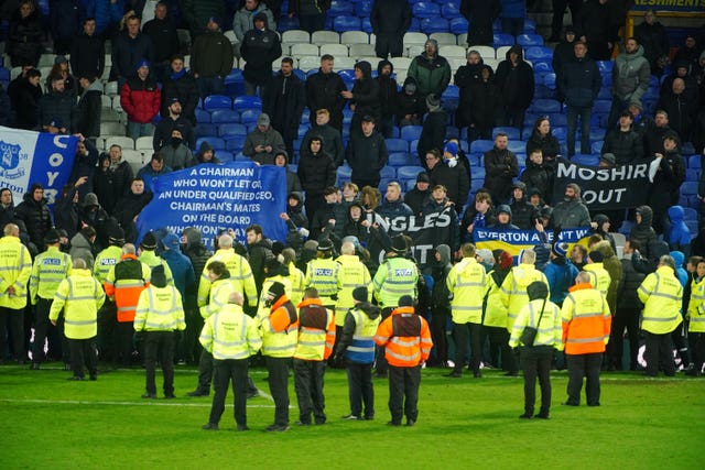 Everton fans hold up banners in protest against the club's board 