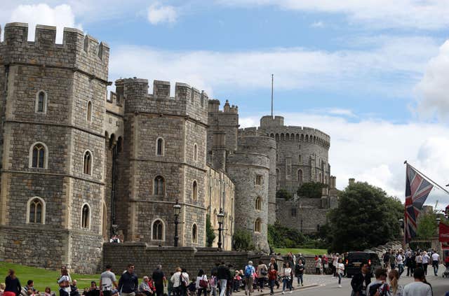 A view of tourists walking past Windsor Castle including the Round Tower in Berkshire