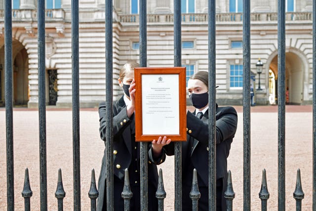 A sign announcing the death of the Duke of Edinburgh, who has died at the age of 99, is placed on the gates of Buckingham Palace, London (Ian West/PA)