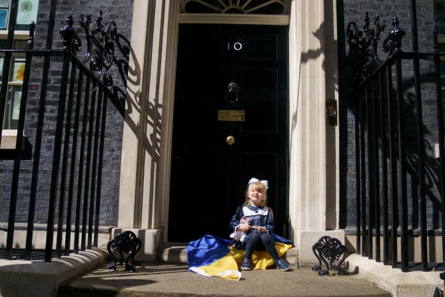 Ukrainian refugee Kira Ryndova, aged three, holds a soft toy as she sits on the steps of 10 Downing Street in London after visiting with her family to meet Prime Minister Boris Johnson, following their arrival in the UK (Victoria Jones/PA)
