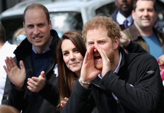 The Duke and Duchess of Cambridge and Prince Harry cheers on runners as they hand out water to runners during the 2017 Virgin Money London Marathon (Chris Jackson/PA)