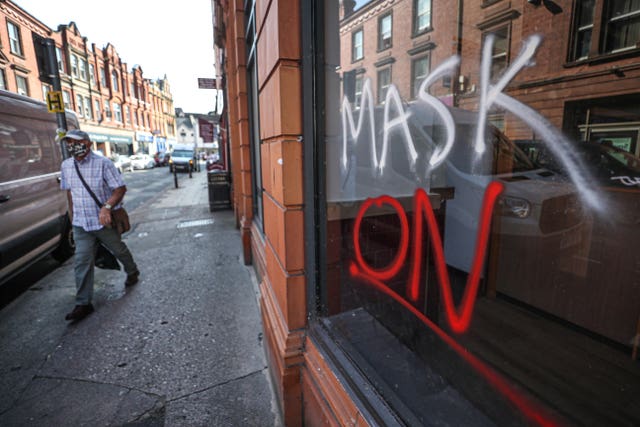 A man wearing a face covering walks past graffiti with the slogan “Mask On” covering a vacant shop window in the High Street in Worcester, some six months on from the evening of March 23 when Prime Minister Boris Johnson announced nationwide restrictions