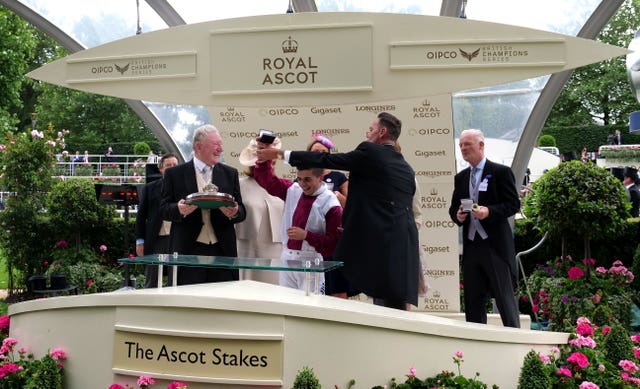 Andrea Atzeni and Willie Mullins are presented with the trophies by Craig Revel Horwood