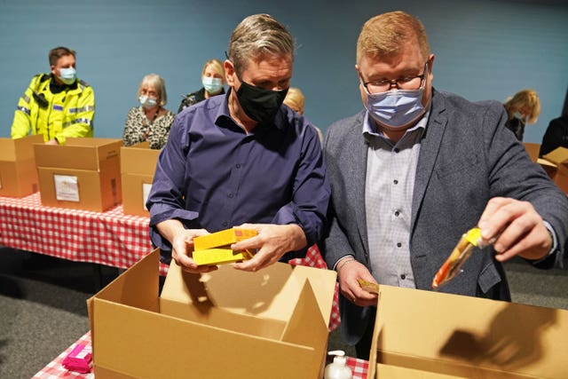 Sir Keir Starmer in 2021 wearing a face mask while helping to pack supplies into boxes for Christmas