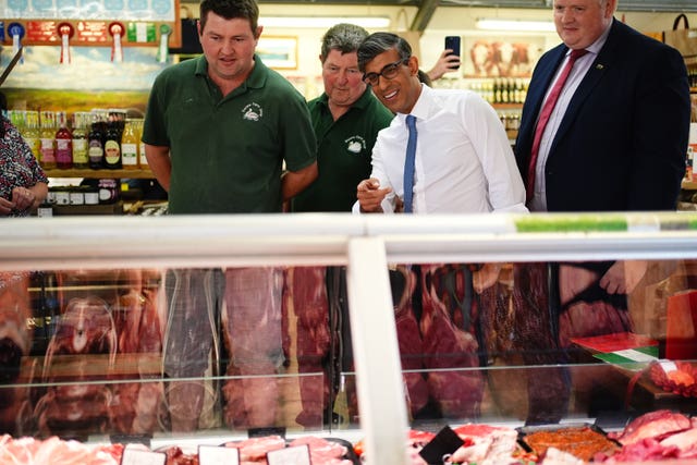 Prime Minister Rishi Sunak points at a meat counter during a visit to a farm shop on the outskirts of Mold