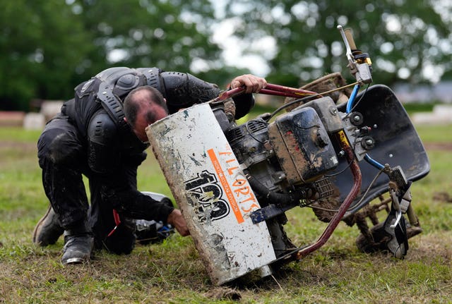 A man looking under his mower