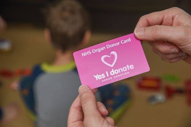 A child in the background and an organ donor card in the foreground