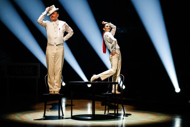 Buswell and McCausland standing on chairs during their routine, wearing matching white suits