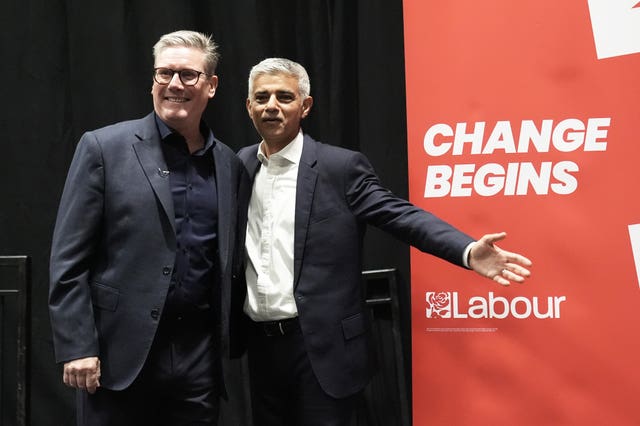 Sir Keir Starmer, left, and Sadiq Khan standing in front of a banner that says 'change begins'