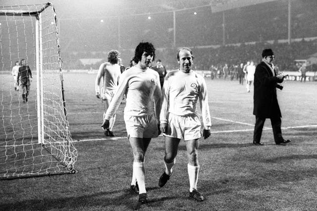 Peter Lorimer and Bobby Charlton walk off the pitch at Wembley after the British Three v the Common Market match in 1973