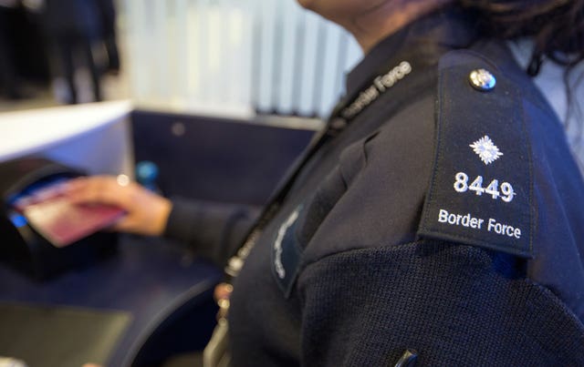 A Border Force officer checks passports (Steve Parsons/PA)
