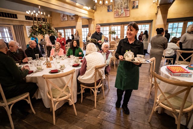 A member of the Highgrove staff walks by the tables carrying pots of tea at the Winter Warmers event 