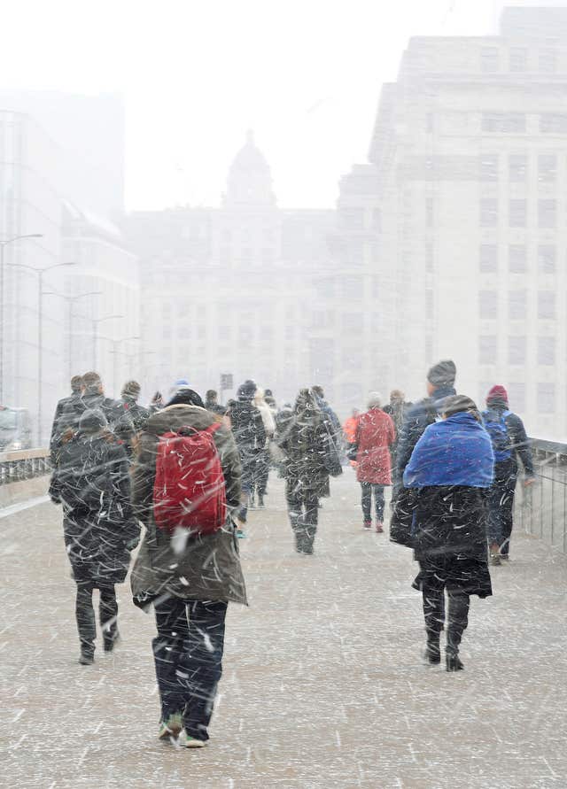 Commuters walking in the snow on London Bridge (Steve Parsons/PA)