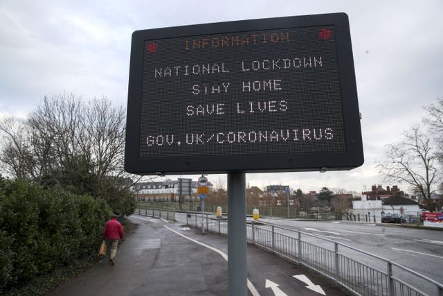 A man passes an information sign notifying people about the national lockdown