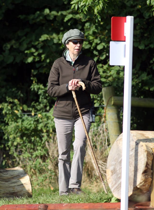 The Princess Royal wearing a large cap and leaning on a walking stick