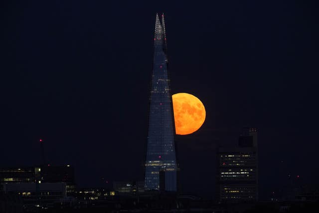 The Sturgeon supermoon, the final supermoon of the year, rises behind The Shard in London