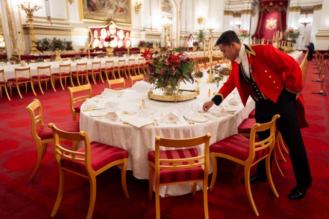 The finishing touches are applied by a senior footman to the tables in the Ballroom of Buckingham Palace, London prior to the State Banquet for the Emir of Qatar Sheikh Tamim bin Hamad Al Thani, during his state visit to the UK