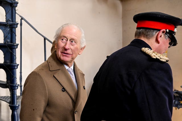 The King looks up as he walks alongside an official during a visit to Tower Brewery in Burton Upon Trent on Monday