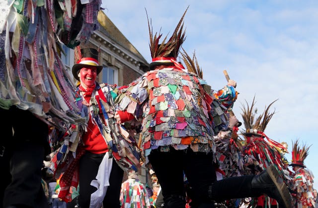 Morris dancers wearing colourful attire parade and dance in the streets of Whittlesea