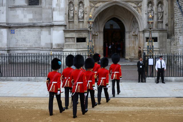Soldiers in ceremonial uniform walk into Westminster Abbey