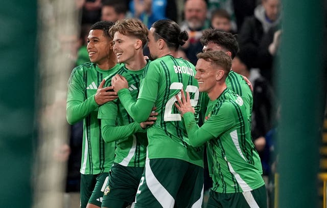 Northern Ireland’s Isaac Price, second left, is embraced by team-mates after scoring against Switzerland