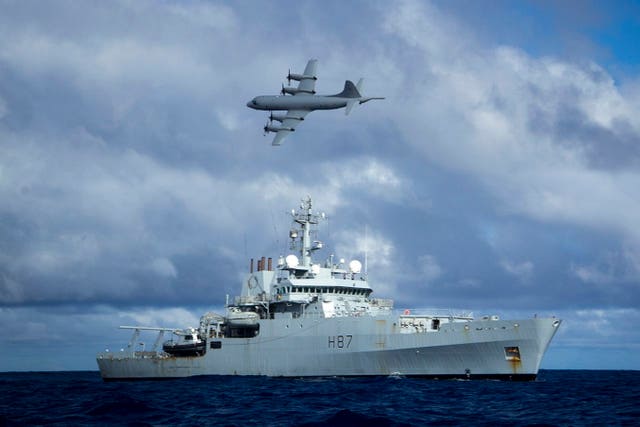 Survey ship HMS Echo, as a Lockheed P-3 Orion flies overhead, during the search for MH370 (Ministry of Defence/PA)
