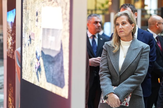 Sophie looks at photographs at the exhibition in the Foreign Office 