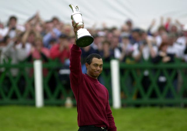 Tiger Woods holds the Claret Jug aloft after winning the Open golf championship with a final score of 19 under par at St. Andrews, Scotland in 2000 