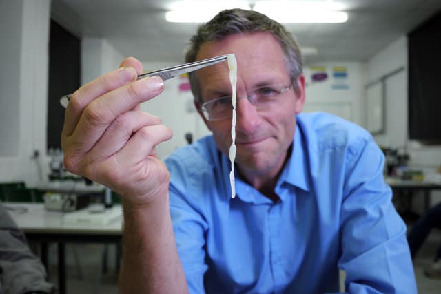 Michael Mosley holding up a piece of human tapeworm