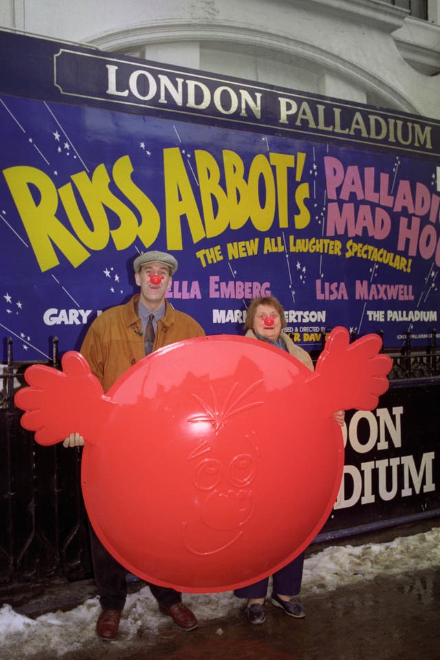 Russ Abbot and Bella Emberg hoist a giant Comic Relief red nose up outside the London Palladium (Michael Stephens/PA)
