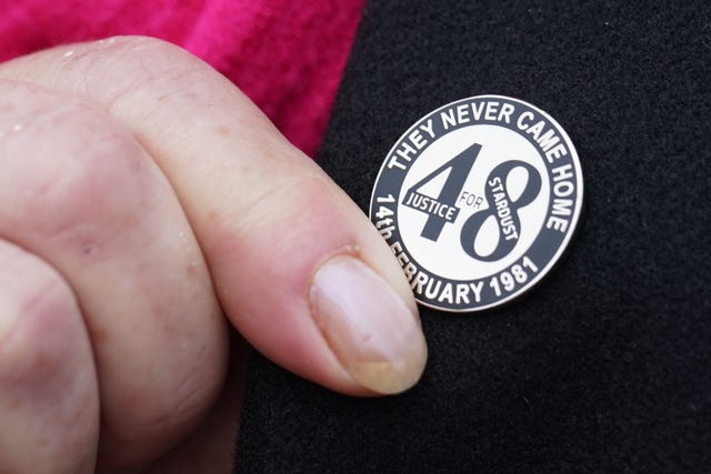 A family member touches her Stardust lapel pin on her way into Dublin Coroner&rsquo;s Court in March 