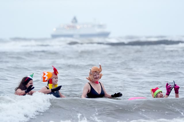 People enjoying a swim on Christmas Eve at Cullercoats Bay in North Tyneside
