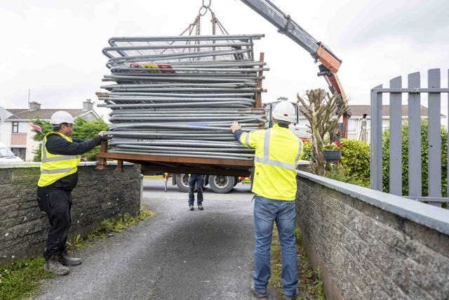 Workers unloading fencing 