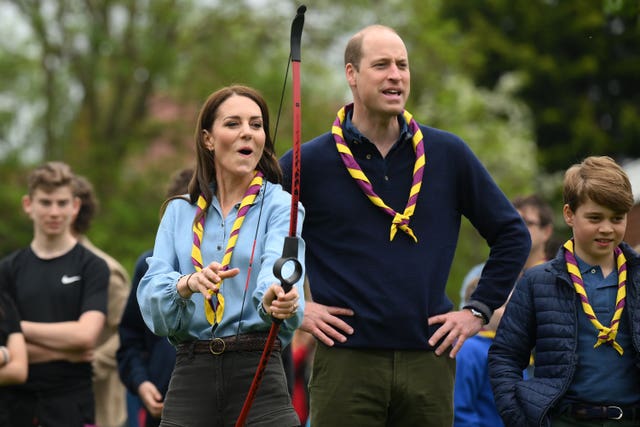The Princess of Wales, watched by the Prince of Wales, tries archery while joining volunteers to help renovate and improve the 3rd Upton Scouts Hut in Slough, as part of the Big Help Out