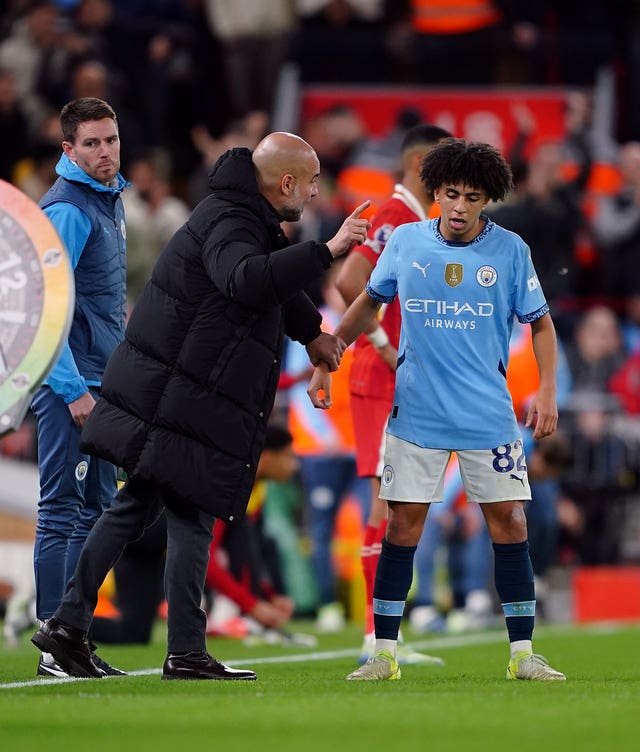 Manchester City manager Pep Guardiola and Rico Lewis during a Premier League match at Liverpool