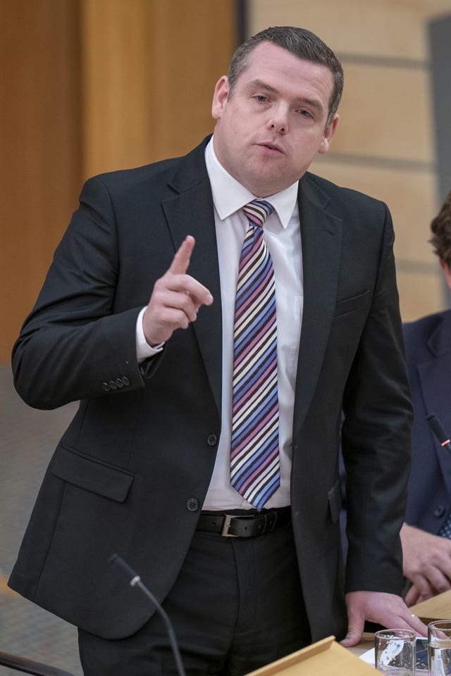 Douglas Ross standing and raising a finger to make a point in Holyrood