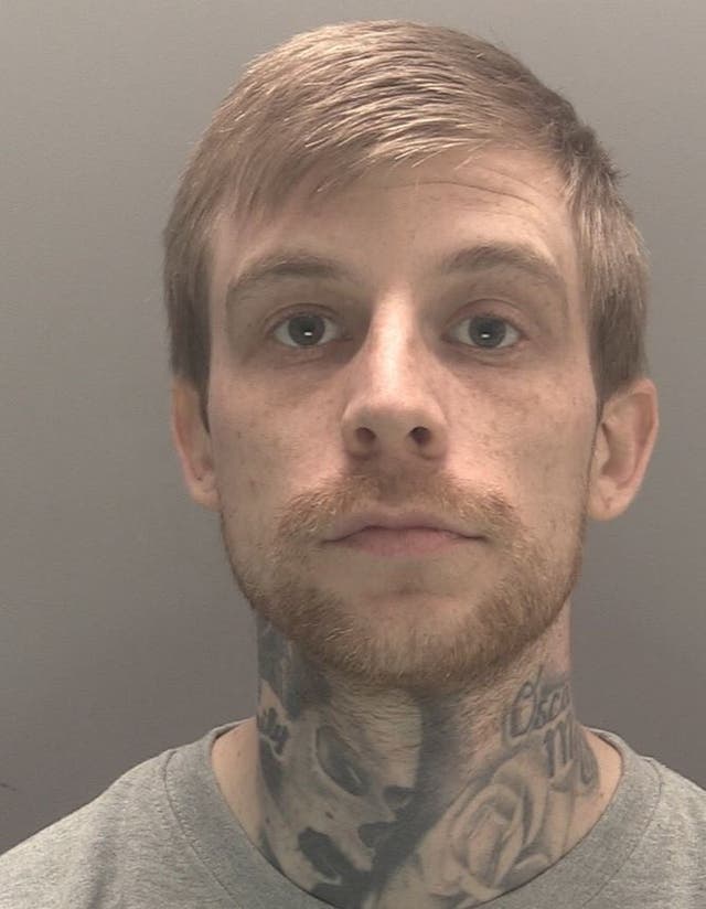 Head shot of a man with a short beard and a tattooed neck