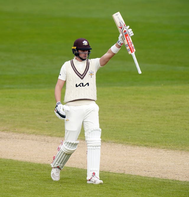 Jamie Smith holds his bat aloft after a half-century for Surrey.