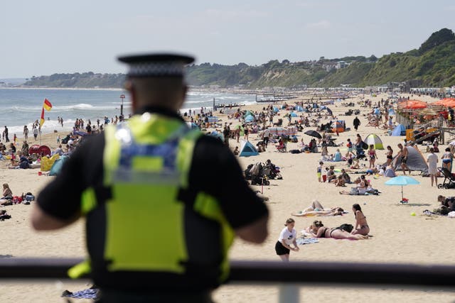 A police officer looks out over Bournemouth beach after a 17-year-old-boy and 12-year-old girl drowned