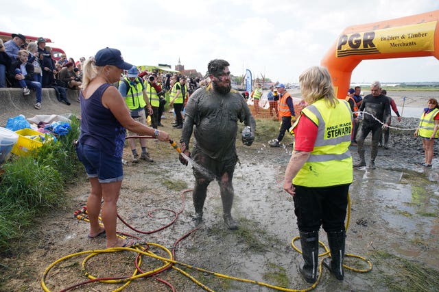 A competitor is hosed down after taking part in the annual Maldon Mud Race, a charity event to race across the bed of the River Blackwater in Maldon, Essex 