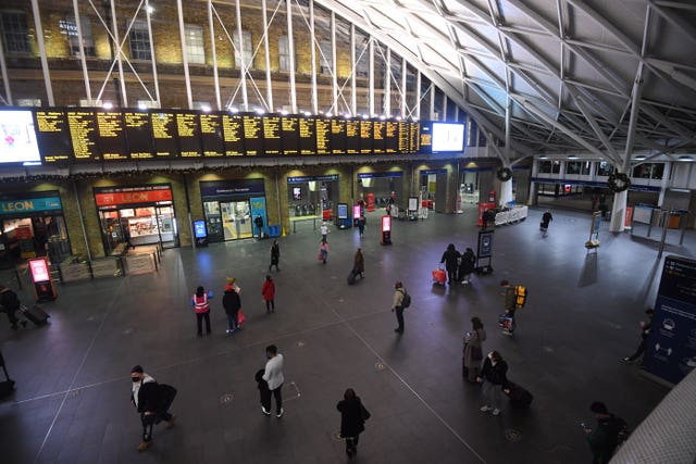 Travellers wait for trains on the concourse at King’s Cross station in central London (Victoria Jones/PA)
