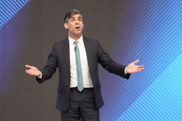 Prime Minister Rishi Sunak addresses the audience with his arms outstretched during a Sky News election event