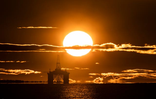 Sun rising behind an oil platform in the North Sea