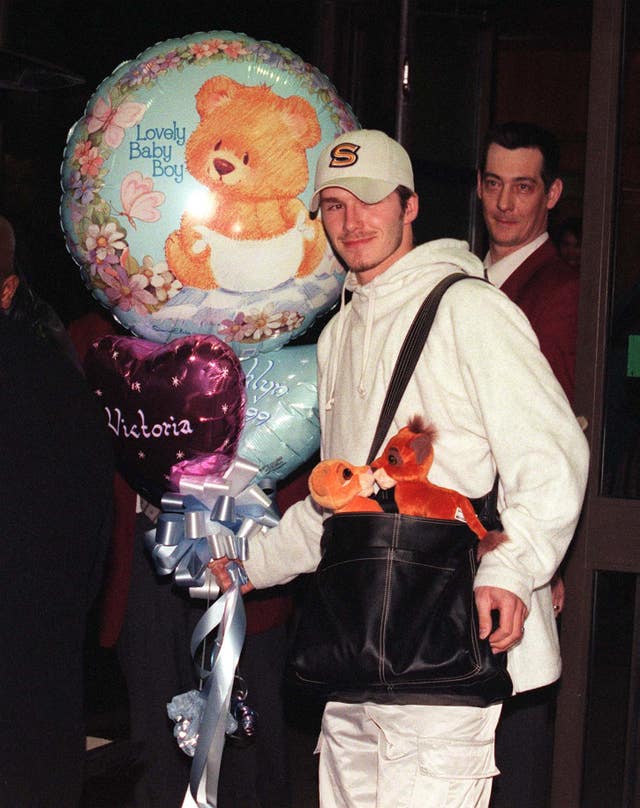 David Beckham carrying toys and balloons at the Portland Hospital after Brooklyn was born