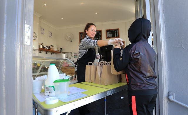 Sarah Marriott hands a lunch pack to a young person