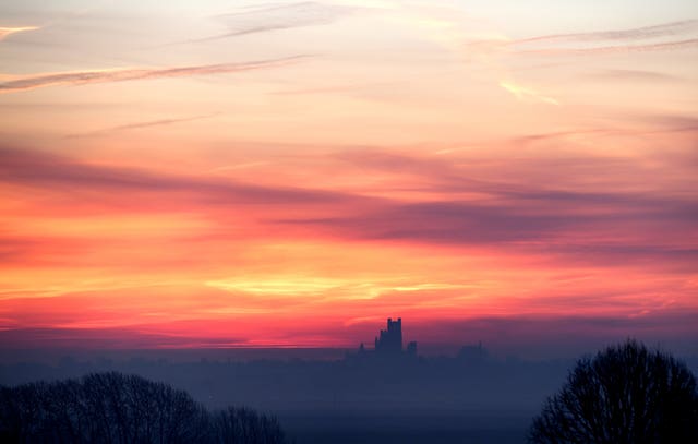 The sun rises behind Ely Cathedral in The Fens