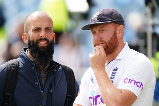 Jonny Bairstow, with hand on chin, stands next to Moeen Ali 