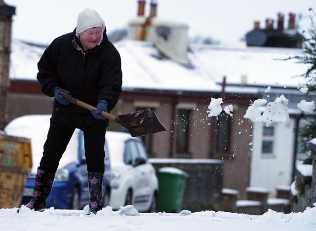 Hazel Kendrick, 78, clears snow in Nenthead, Cumbria, following Storm Freya