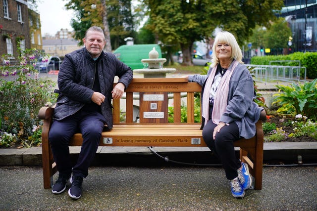 A man and a woman sitting on a bench