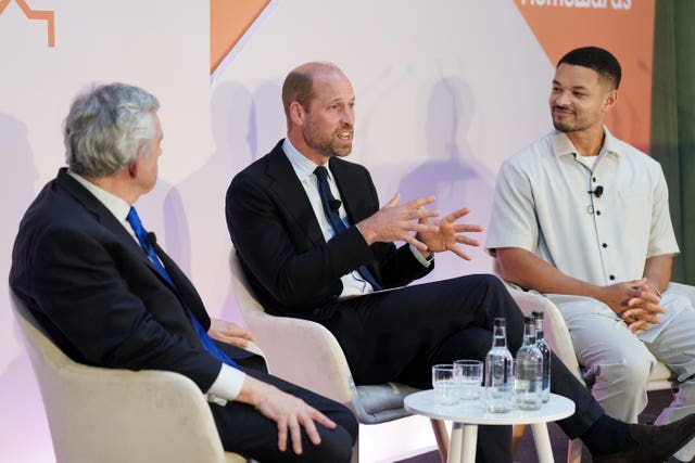 Three men sitting in chairs giving a speech